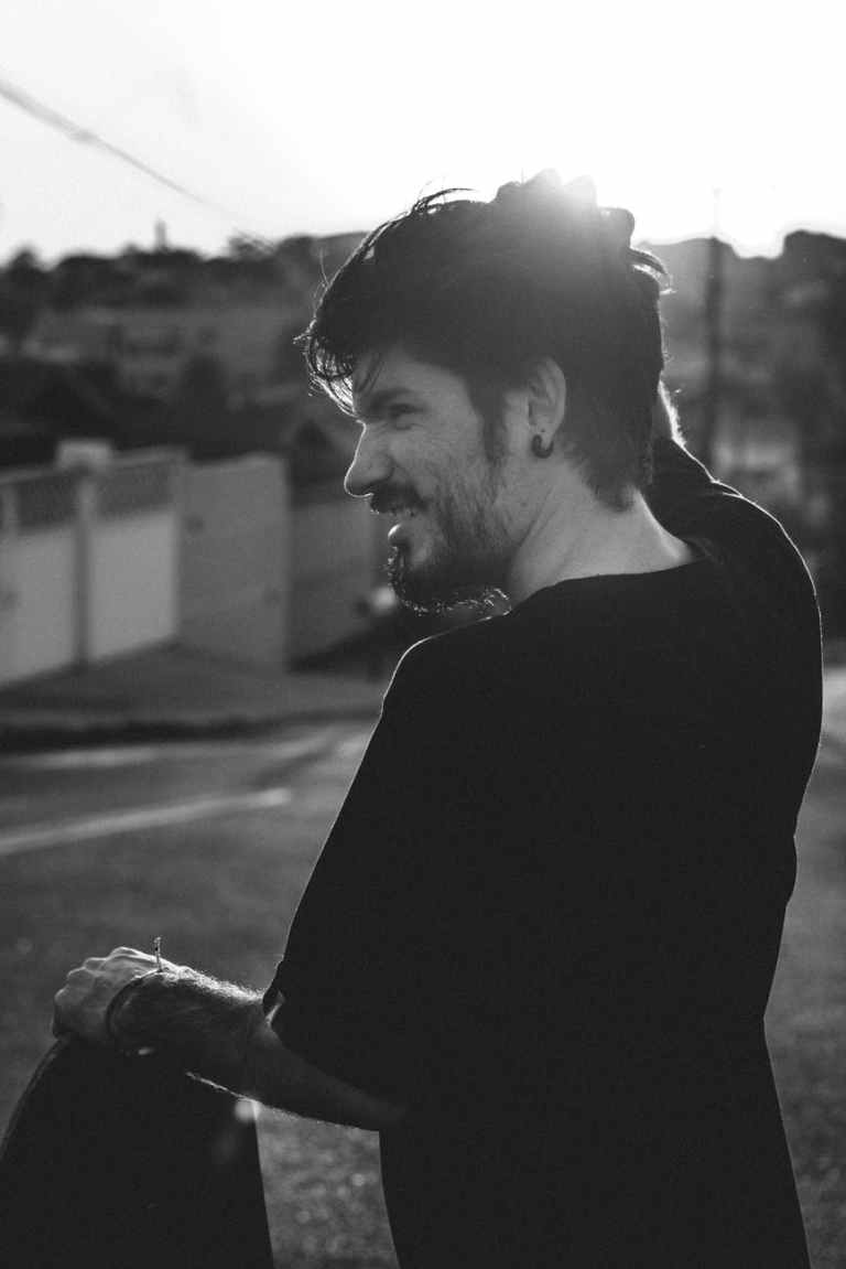 grayscale photo of man standing while scratching head